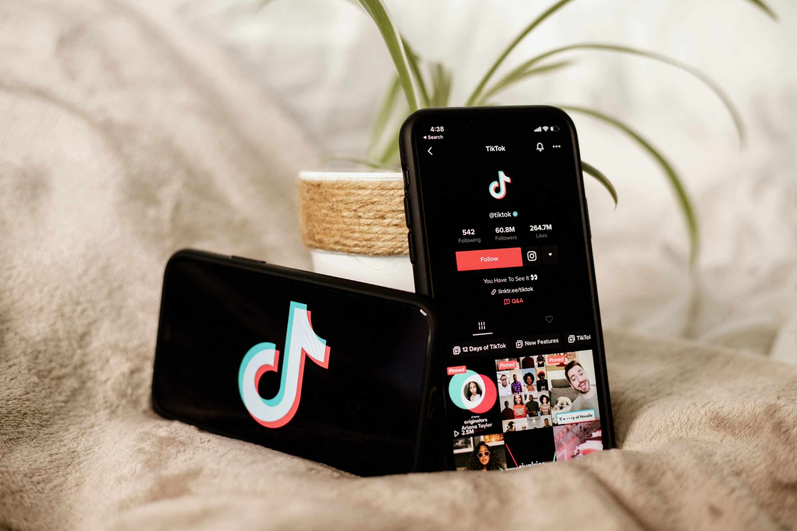 Deux téléphones, un couché à l’horizontal et un vertical avec l’application TikTok ouverte sur le compte officiel TikTok