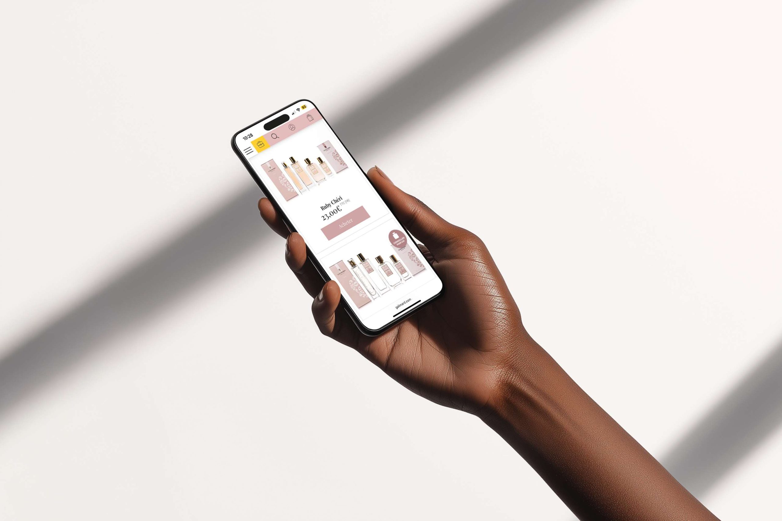 Main tenant un smartphone affichant une boutique en ligne de parfums avec un design épuré.